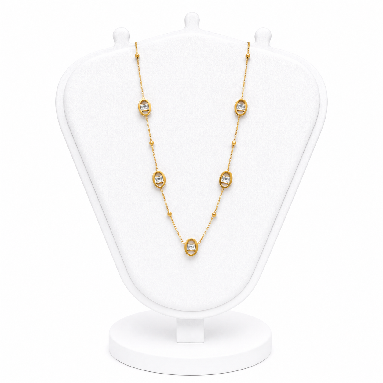 Gold necklace with diamond-like stones on a white mannequin bust
