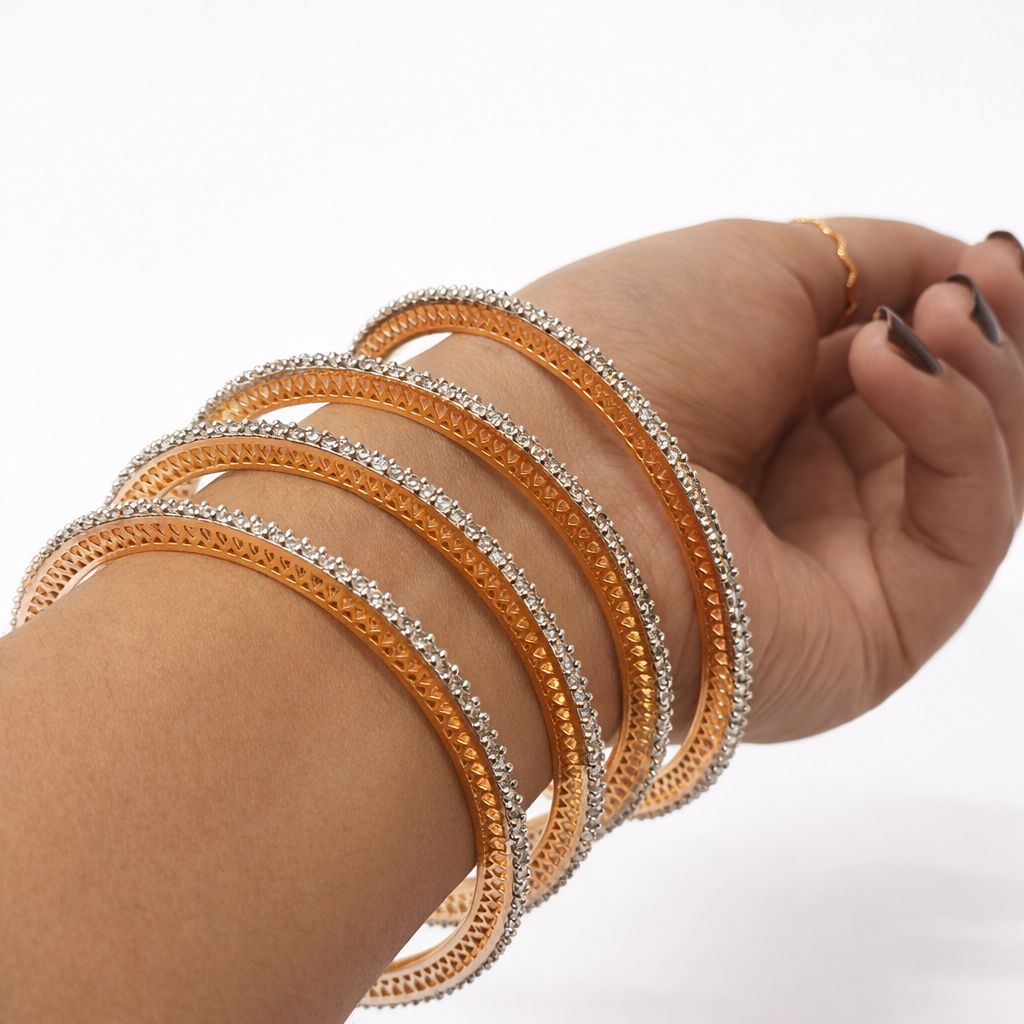 Hand wearing multiple gold and silver bangles on a white background