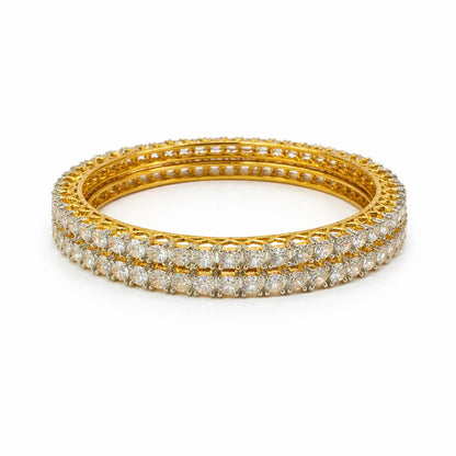 A gold-toned triple bangle bracelet set with rows of sparkling clear pavé stones, photographed on a clean white background.