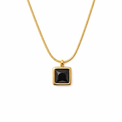 Silver necklace with a black gemstone pendant on a white background