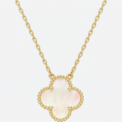 Gold necklace with a clover-shaped pendant on a light gray background