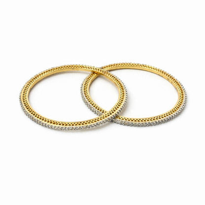 Two gold bangles with diamond accents on a white background
