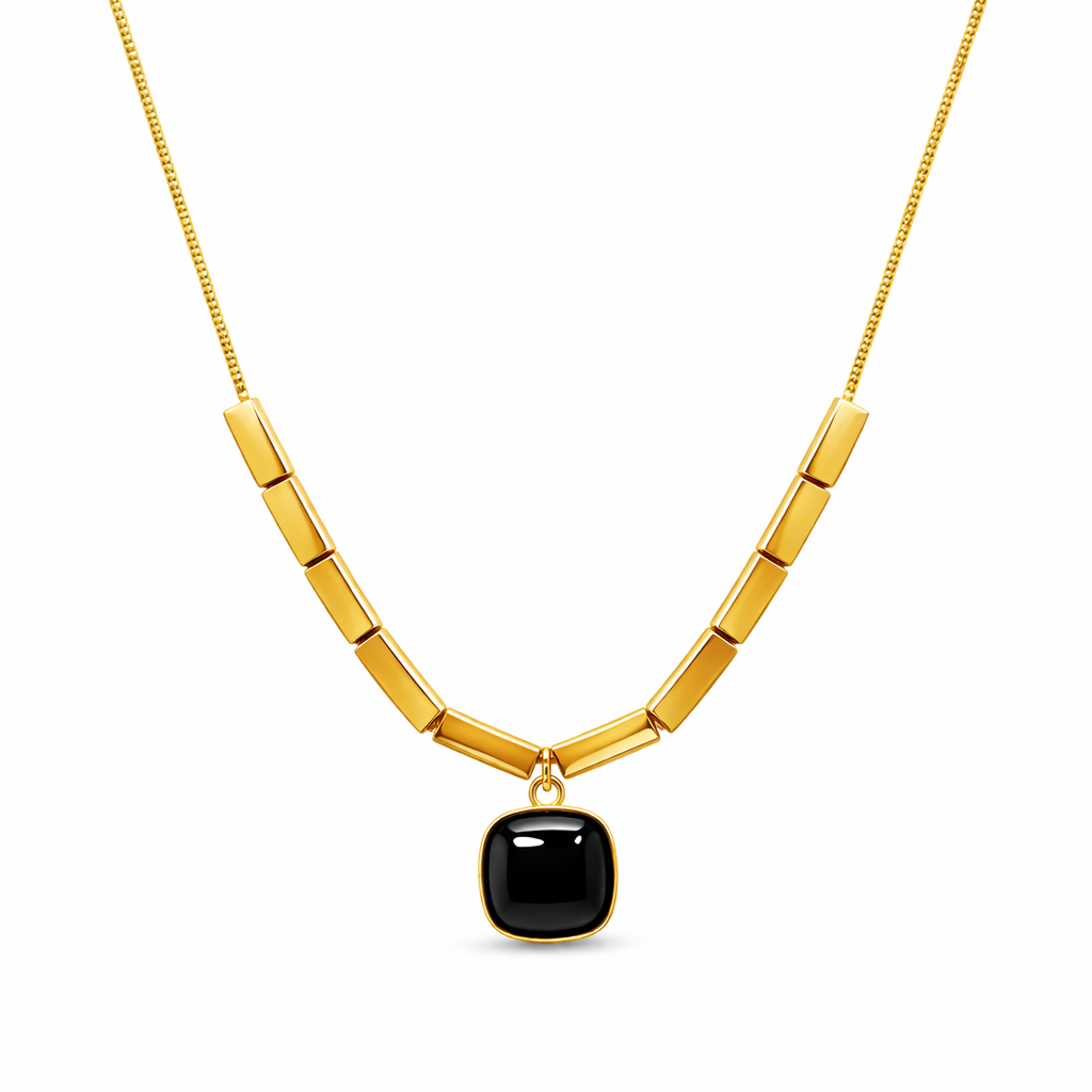 Gold necklace with a black pendant on a white background