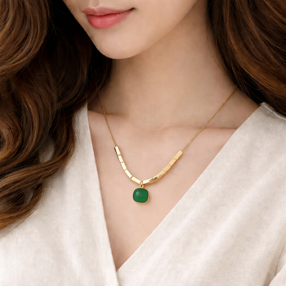 Gold necklace with a green pendant worn by a model