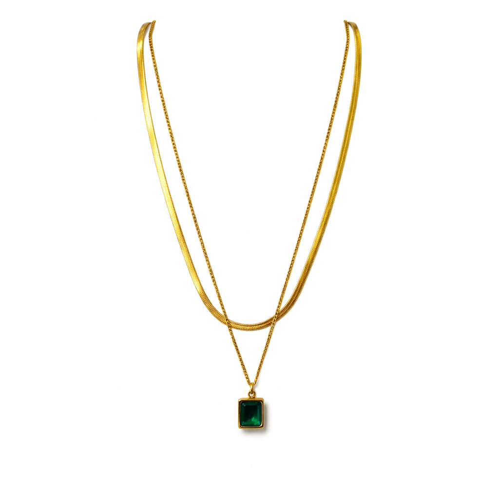 Gold necklace with a green pendant on a white background