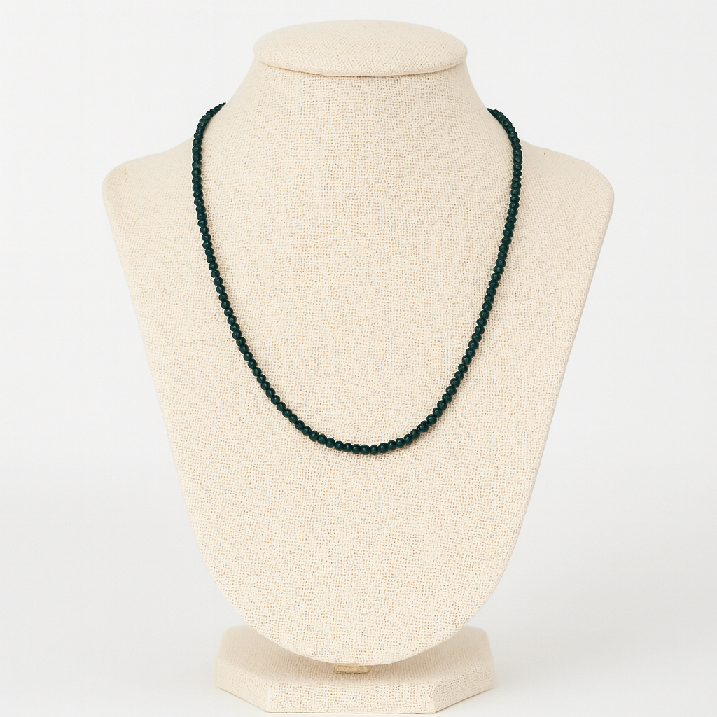 Green beaded necklace on a beige mannequin bust against a white background