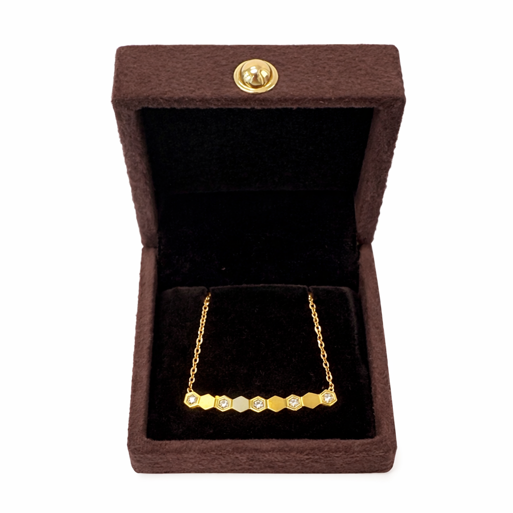 Gold necklace in a brown jewelry box with a gold clasp.