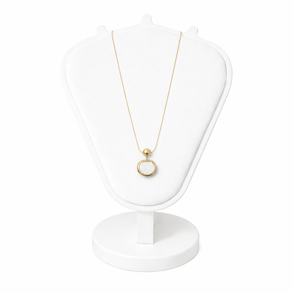Gold necklace with a pendant on a white stand against a white background