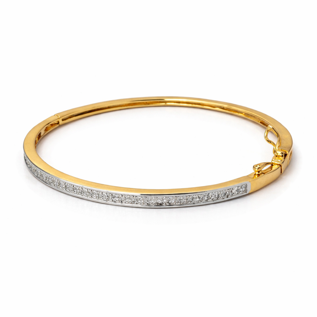 Gold bangle with embedded stones on a white background