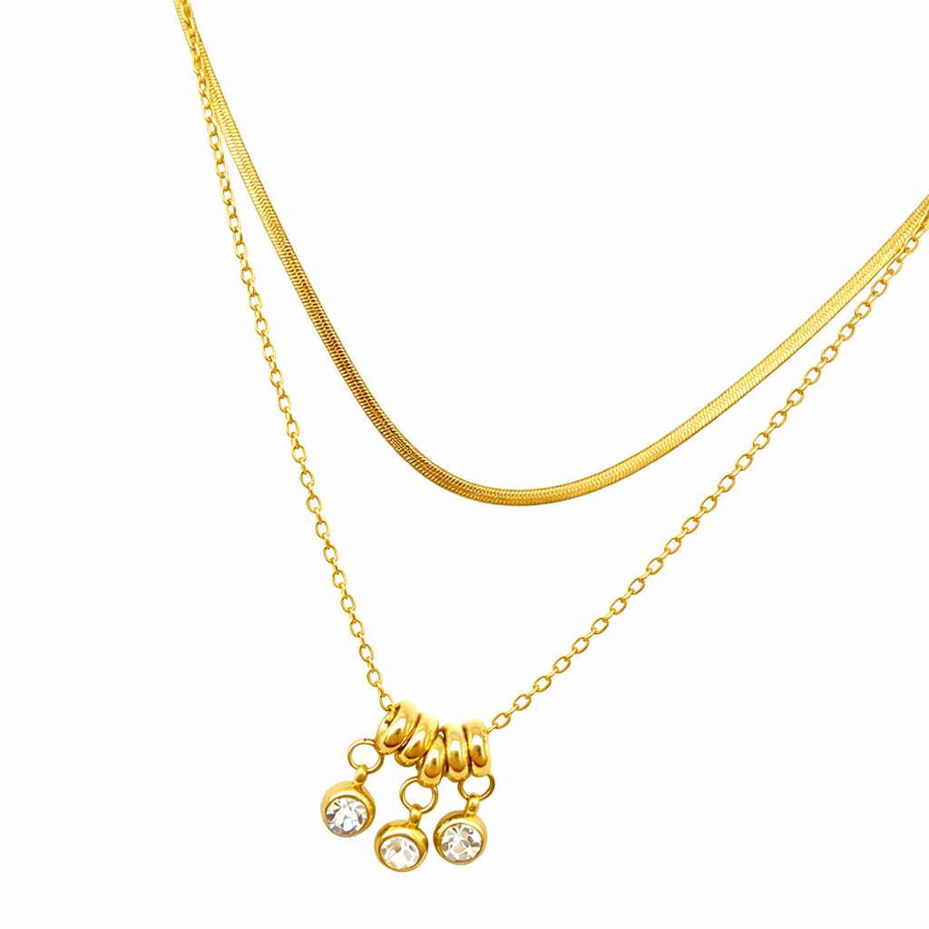 Gold necklace with a small pendant on a white background