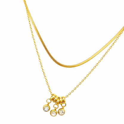 Gold necklace with a small pendant on a white background