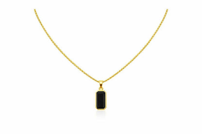 Gold necklace with a black pendant on a white background