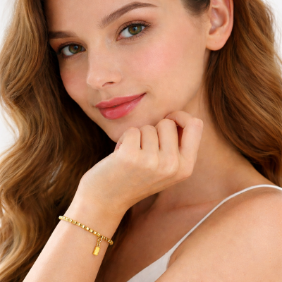 Woman wearing a gold bracelet on a white background