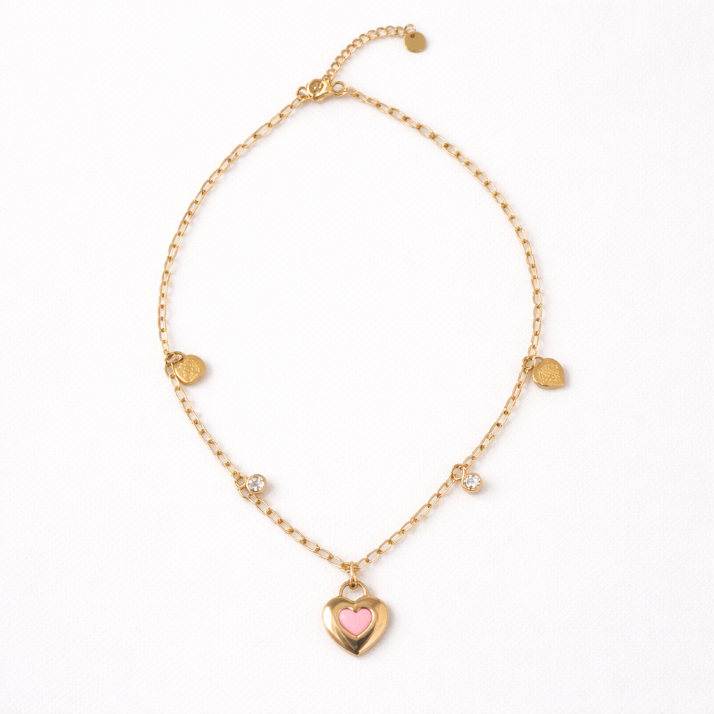 Gold bracelet with a heart-shaped charm on a white background