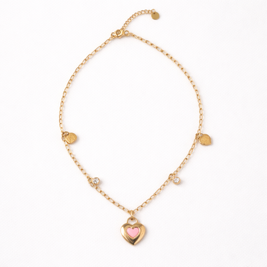 Gold bracelet with a heart-shaped charm on a white background