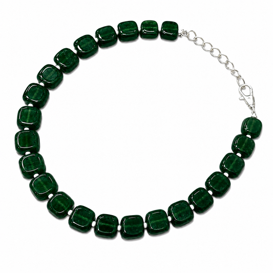 A beaded necklace featuring glossy, rounded square-cut dark green stones, arranged in a circle with a silver-tone extender chain and lobster clasp on a plain white background.