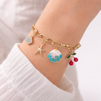 Bracelet with charms on a wrist against a white background