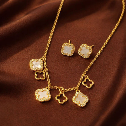 Gold necklace and earrings set on a brown fabric background