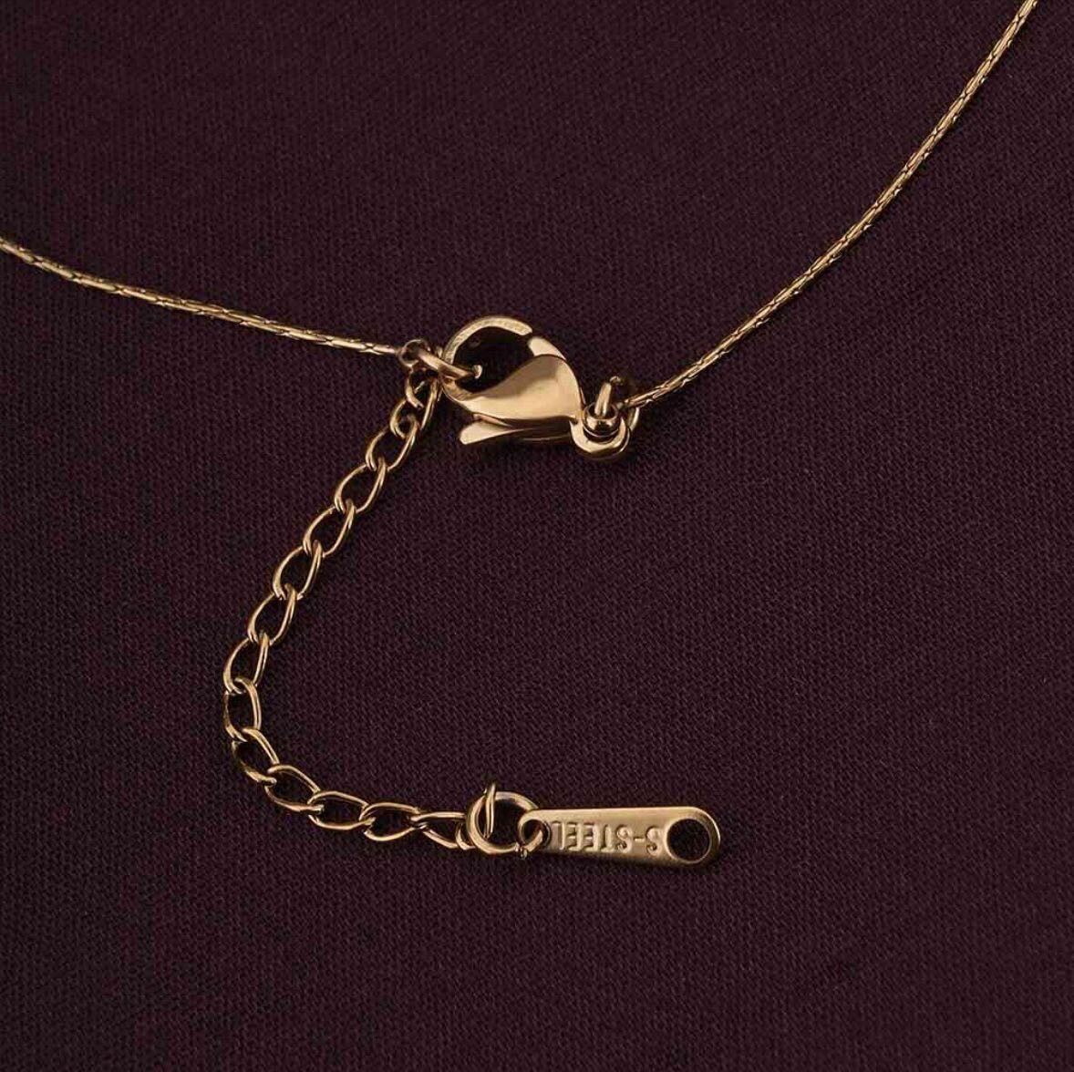 Gold necklace with clasp on a dark purple background