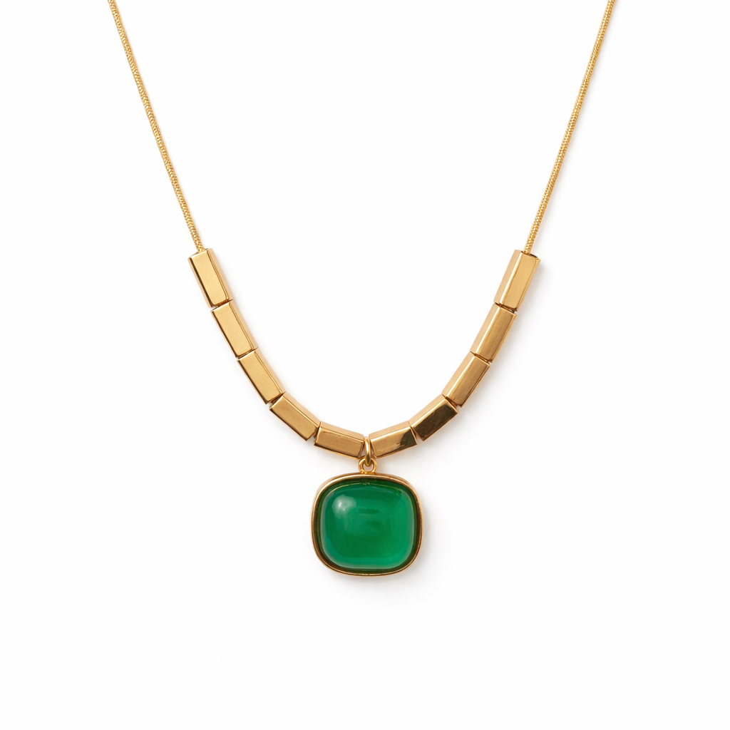Gold necklace with a green pendant on a white background