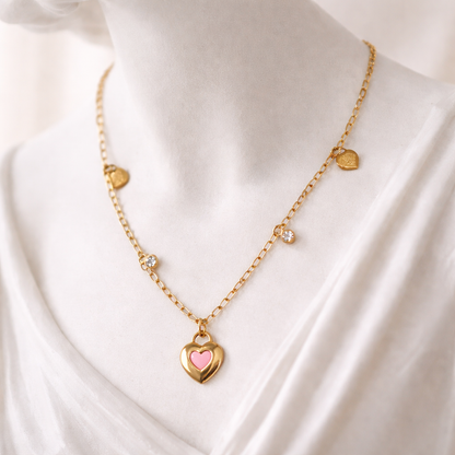 Gold necklace with heart-shaped pendant on a white fabric background