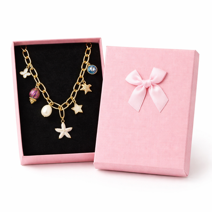 Gold necklace with starfish charms in a pink gift box on a white background