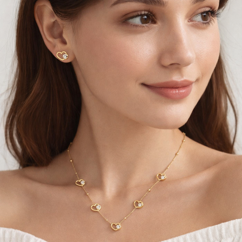 Woman wearing a gold necklace and earrings with a neutral background