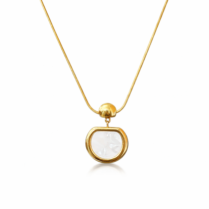 Gold necklace with a clear pendant on a white background