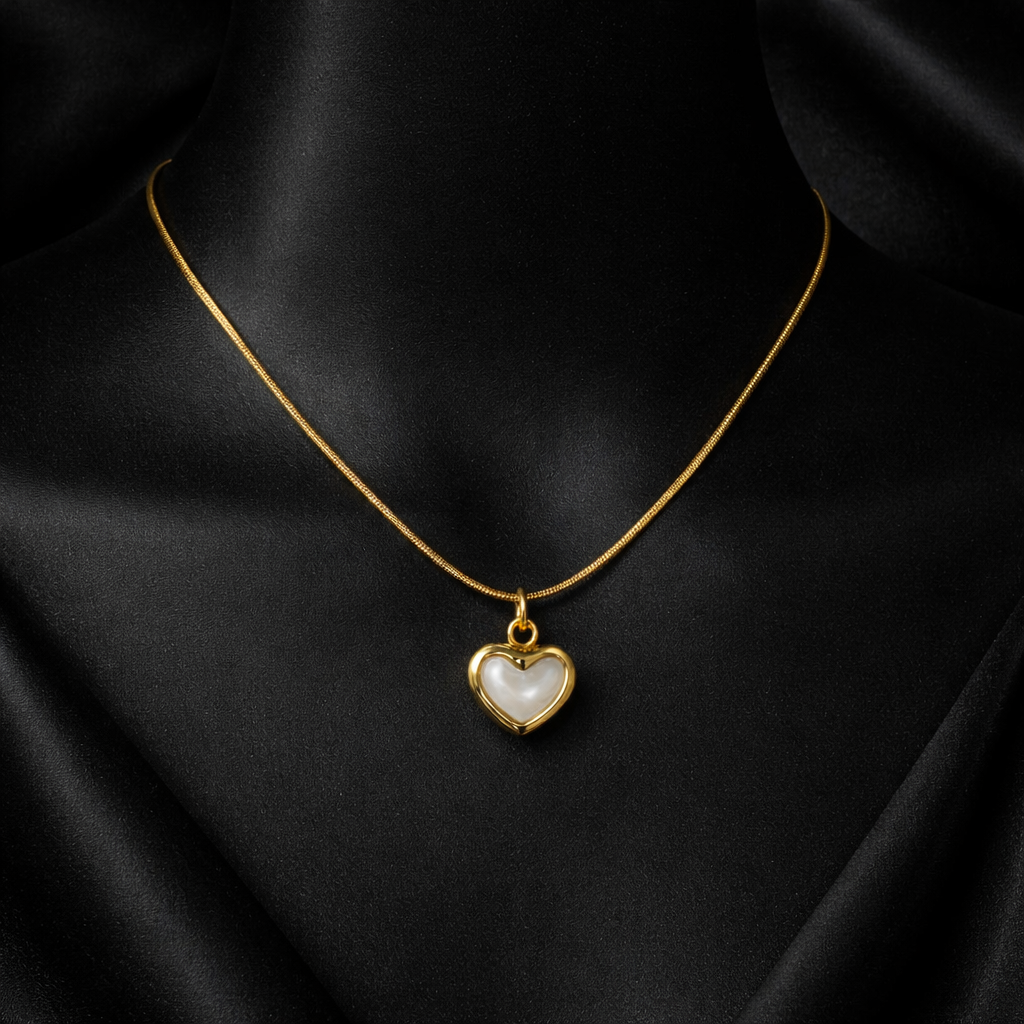 Gold necklace with a heart-shaped pendant on a black background