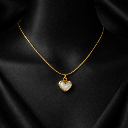 Gold necklace with a heart-shaped pendant on a black background