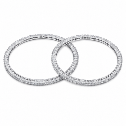 Two overlapping silver-toned bangles covered in small clear stones, displayed on a clean white background.
