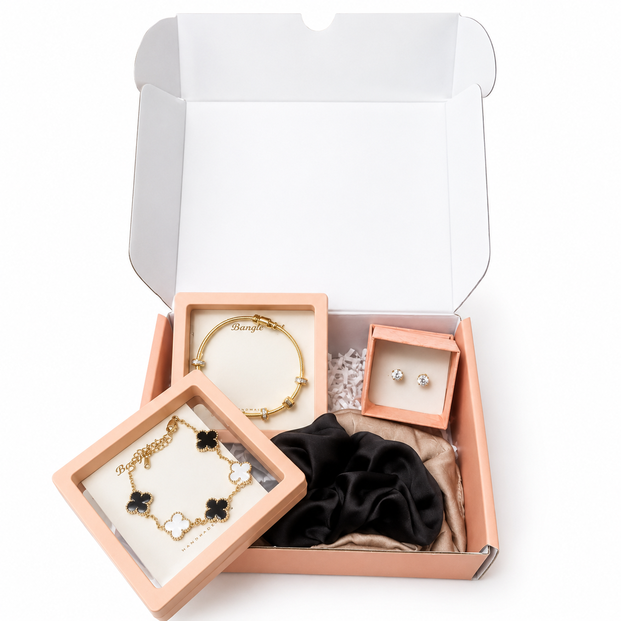 Jewelry set including bracelets and earrings in a pink box on a white background