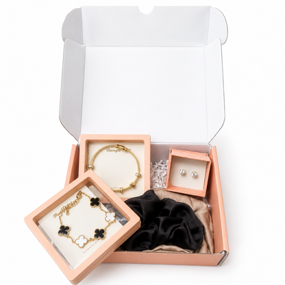 Jewelry set including bracelets and earrings in a pink box on a white background