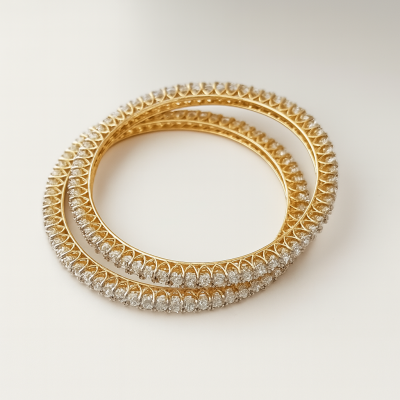 Two gold and diamond-studded bangles on a white background