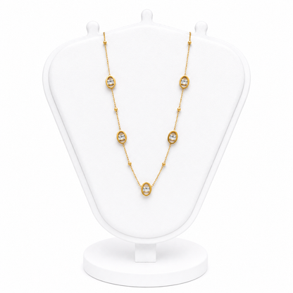 Gold necklace with diamond-like stones on a white mannequin bust