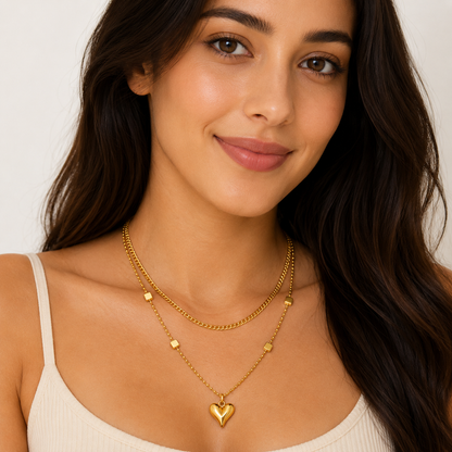 Woman wearing a gold necklace with a heart pendant on a plain background