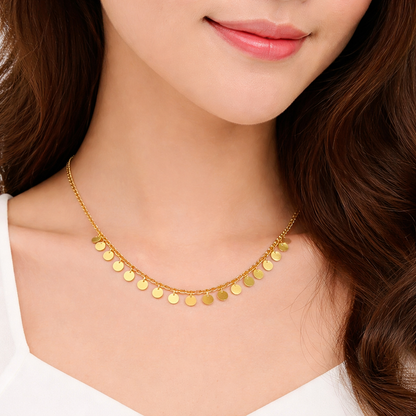 Gold necklace worn by a model with a plain background
