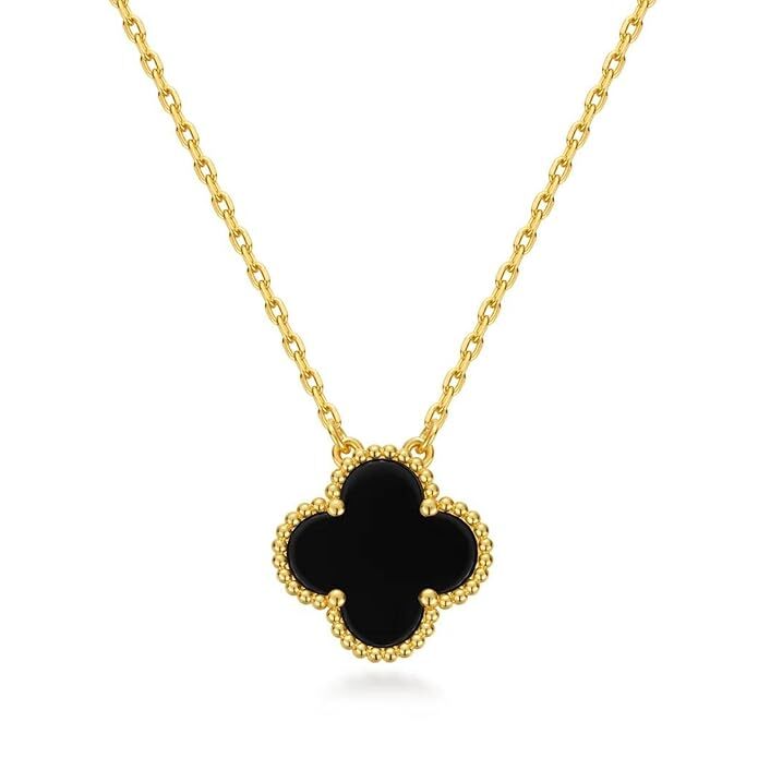 Gold necklace with a black clover pendant on a white background