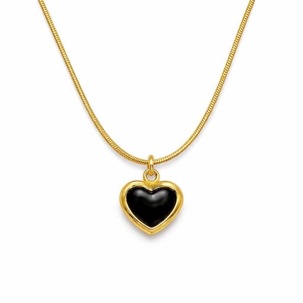 A gold heart pendant necklace with a smooth black center, suspended from a gold snake chain on a plain white background.