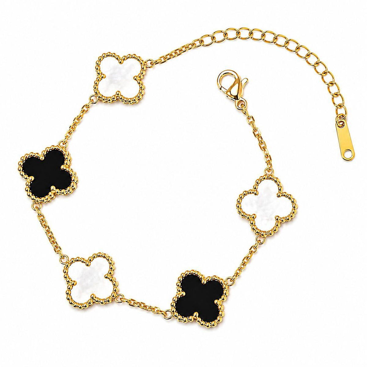Gold bracelet with black and white clover-shaped charms on a white background