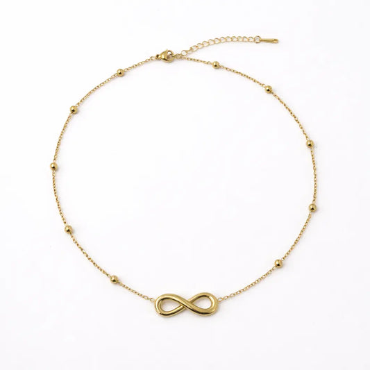 Gold infinity necklace on a white background