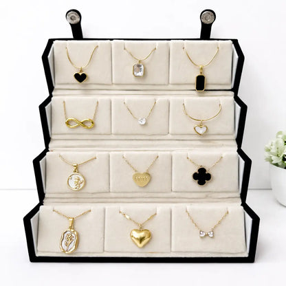 Display of various gold necklaces with pendants on a white background