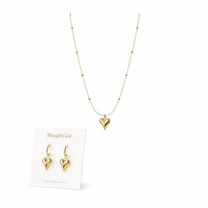 Gold heart jewelry set featuring a delicate beaded chain necklace with a central heart pendant and matching drop earrings, displayed on a white BangleCart card against a white background.