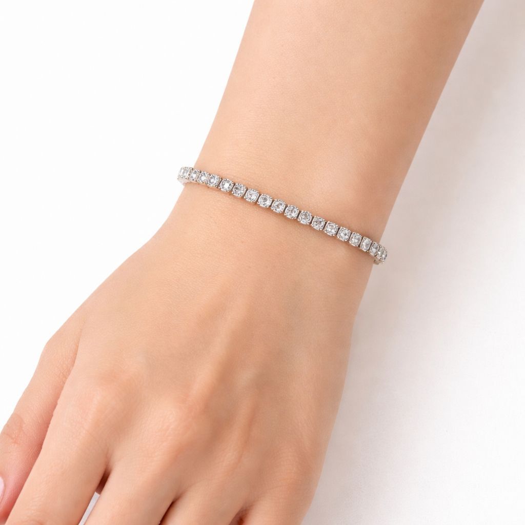 Silver bracelet with clear stones on a wrist against a white background

