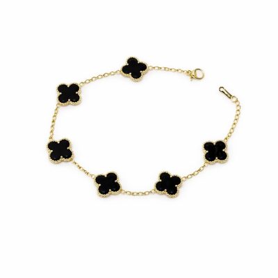 Gold bracelet with black clover-shaped charms on a white background