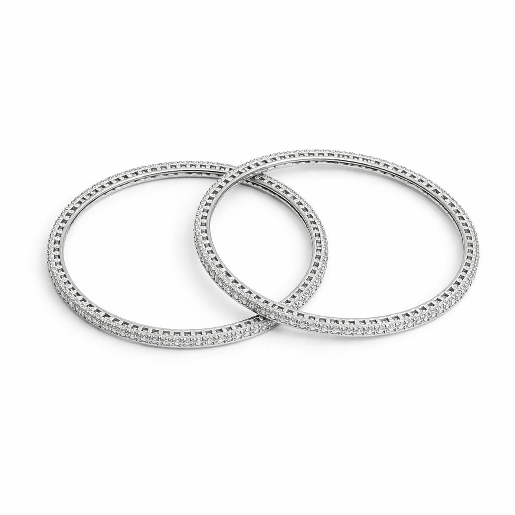 Two silver bangles with diamond accents on a white background