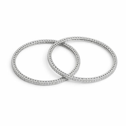 Two silver bangles with diamond accents on a white background