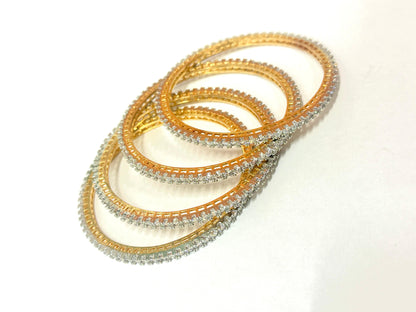 Set of gold and silver bangles on a white background