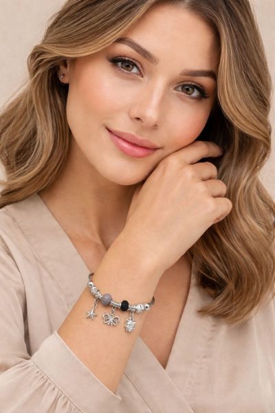 Woman wearing a bracelet with charms against a neutral background