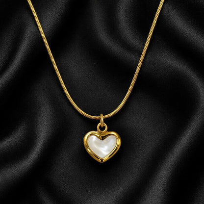 Gold necklace with a heart-shaped pendant on black fabric